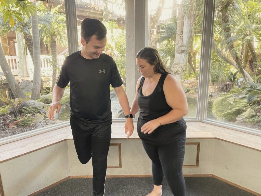 An instructor steadying a man as he balances on one leg