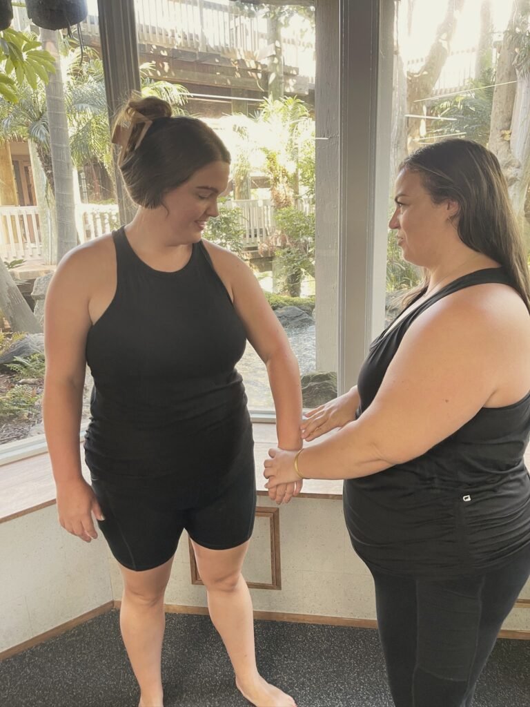 An instructor adjusting a woman's wrist position